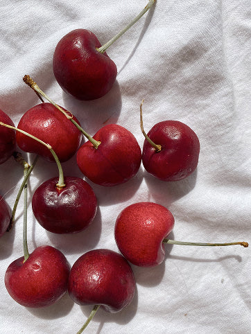 Red cherries on a white cloth, for 'Create Your Own Mantra Board' to inspire self discovery 